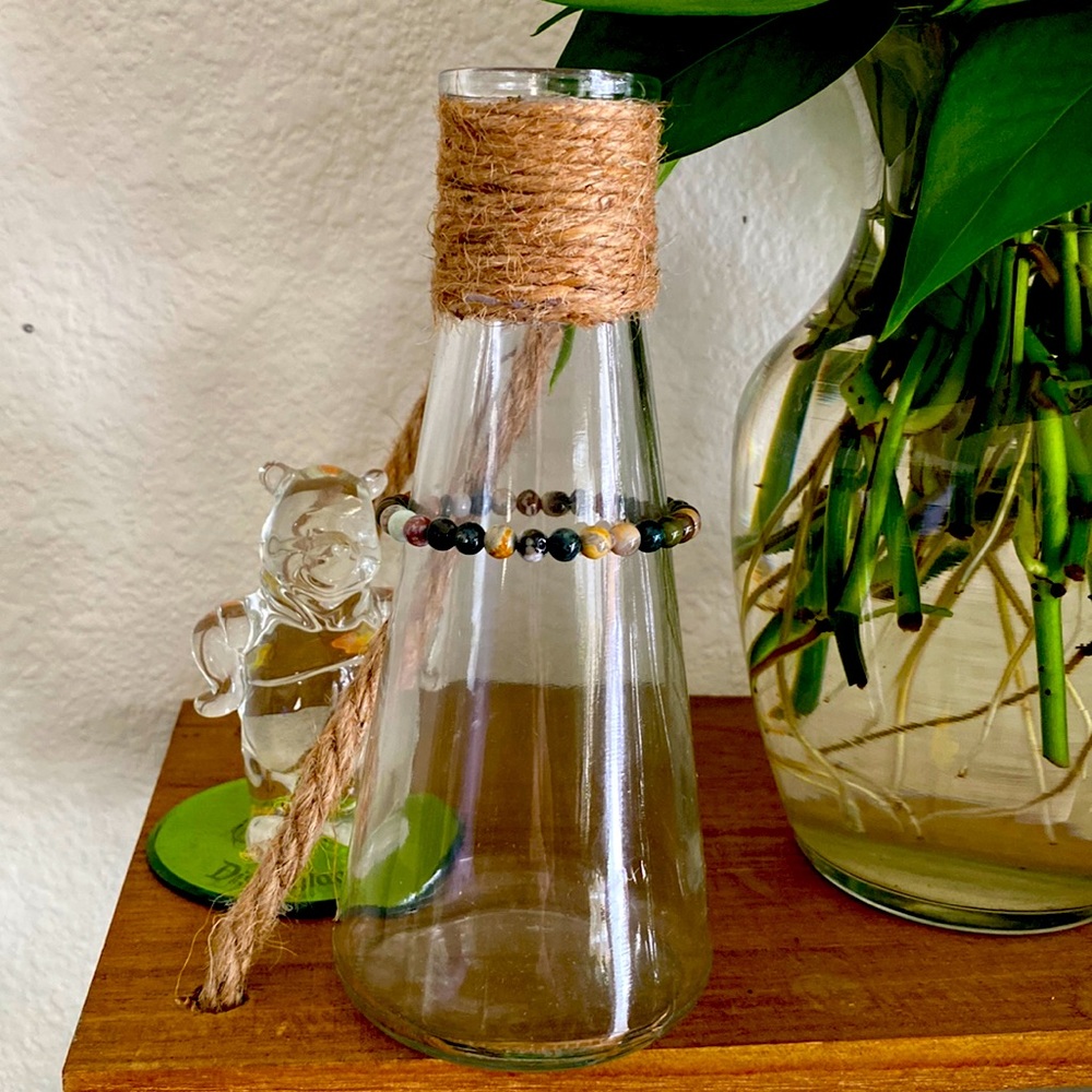 Glass vase with a crystal necklace and plant trimmings
